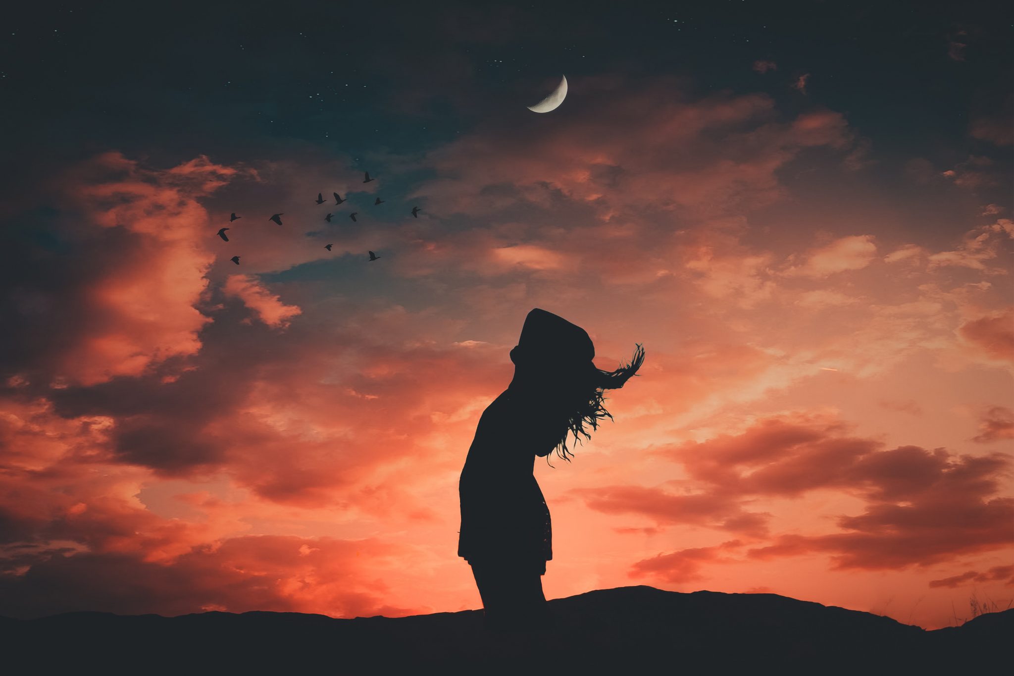 Silhouette of a woman at dawn with crescent moon